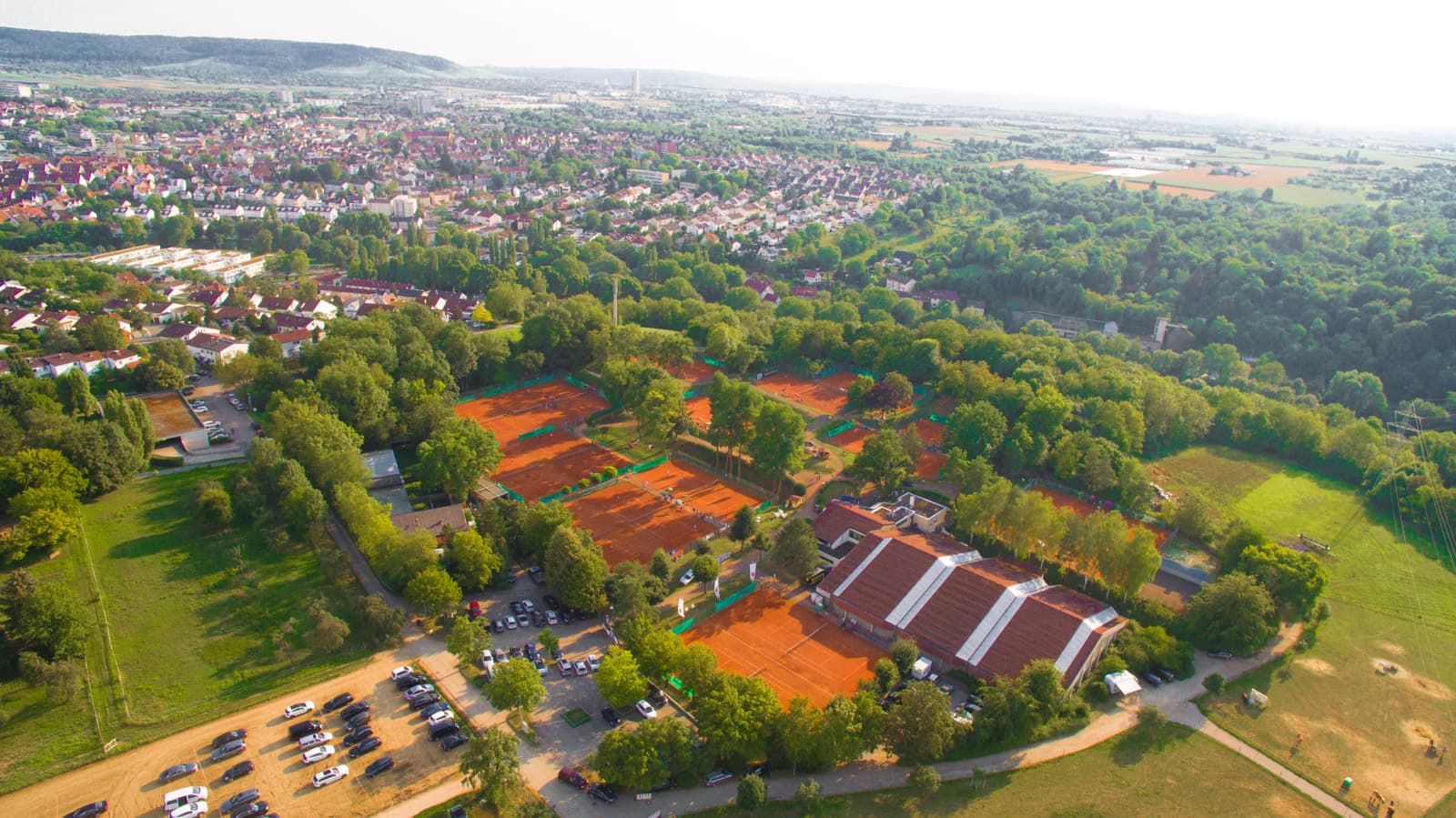 Das Bild zeigt die Club-Anlage mit Blick in Richtung Süd-West. Am unteren Ende ist die Tennishalle zu erkennen, umgeben von 18 Freiplätzen. Der Hintergrund zeigt Waiblingens Zentrum.